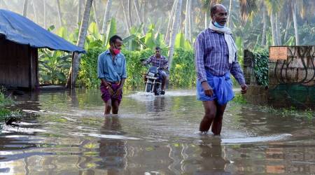 Commuters wade through a waterlogged street after heavy rain in Thiruvananthapuram (PTI Photo)