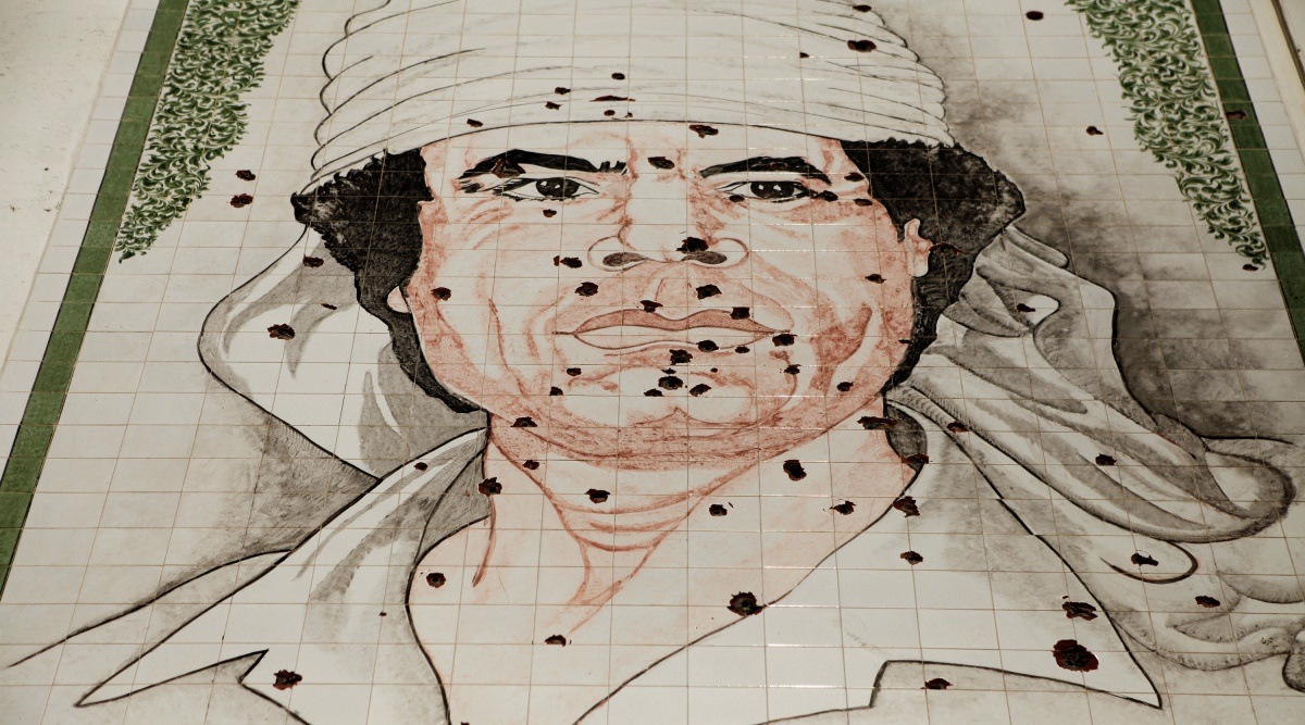 A mosaic of Moammar Gadhafi pocked with bullet holes on the side of an apartment building in Tripoli, Libya, Aug. 27, 2011.(New York Times)