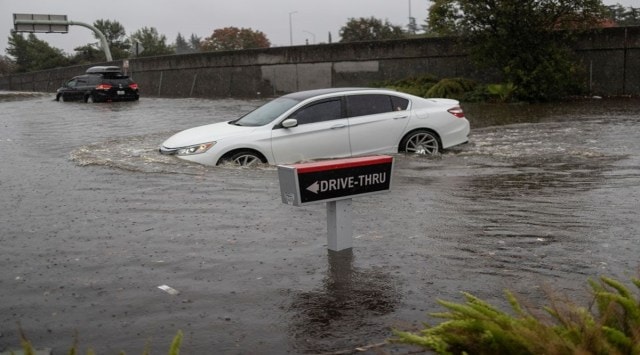A vehicle drives through a flooded area as a powerful storm drenched northern California in Fairfield, California, U.S. October 24, 2021. Reuters/Carlos Barria