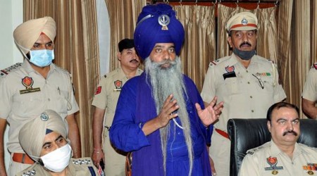 Police personnel with accused Nihang Singh for his alleged involvement in the murder of Lakhbir Singh, who was killed at a farmers' agitation site in Delhi, during a media briefing in Amritsar, Saturday, Oct. 16, 2021. (PTI Photo)