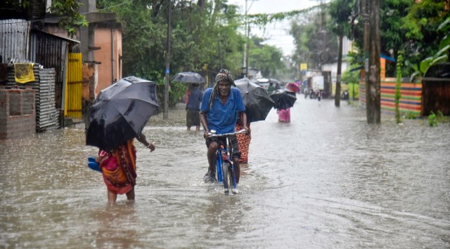 South Dinajpur: Commuters wade through a waterlogged road during heavy rain at Balurghat in South Dinajpur district, Wednesday, Oct. 20, 2021. (PTI Photo)