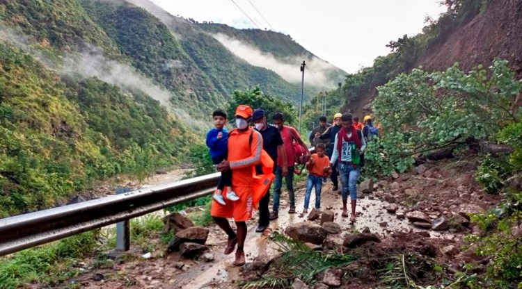 This photograph provided by India’s National Disaster Response Force (NDRF) shows NDRF personnel rescuing civilians stranded following heavy rains at Chhara village near Nainital, Uttarakhand. 
(National Disaster Response Force via AP)
