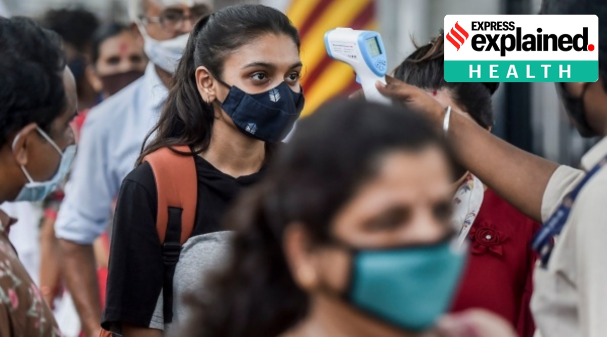 A health worker checks the temperature of a traveller at a railway station in Mumbai. (PTI)
