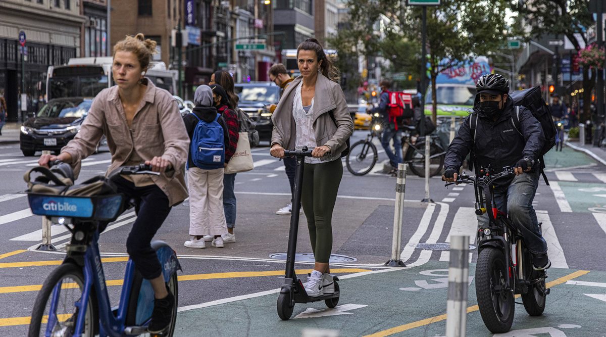 A woman rides an electric scooter in midtown Manhattan on Sept. 29, 2021. Many people turned to electric scooters to avoid subways and buses during the pandemic and intend to keep using them even as the outbreak wanes. (Hiroko Masuike/The New York Times)