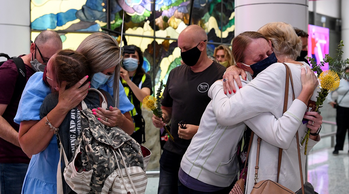 Travellers arriving on the first quarantine free international flights are embraced by family at Sydney International Airport. (Reuters)
