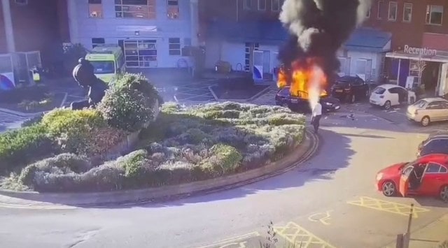 A surveillance camera footage shows a man extinguishing a burning taxi following an explosion outside Liverpool Women's hospital in Liverpool. (Reuters)
