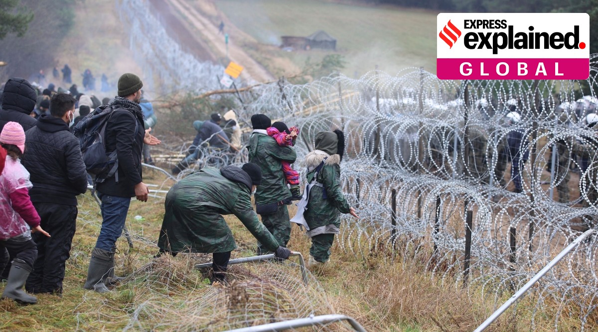 Migrants from the Middle East and elsewhere break down the fence as they gather at the Belarus-Poland border near Grodno, Belarus, Monday, Nov. 8, 2021.(Leonid Shcheglov/BelTA via AP, File)
