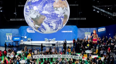 A giant puppet walks through the Action Zone inside the venue of the COP26 UN Climate Summit in Glasgow, Scotland, Tuesday, Nov. 9, 2021. (AP)