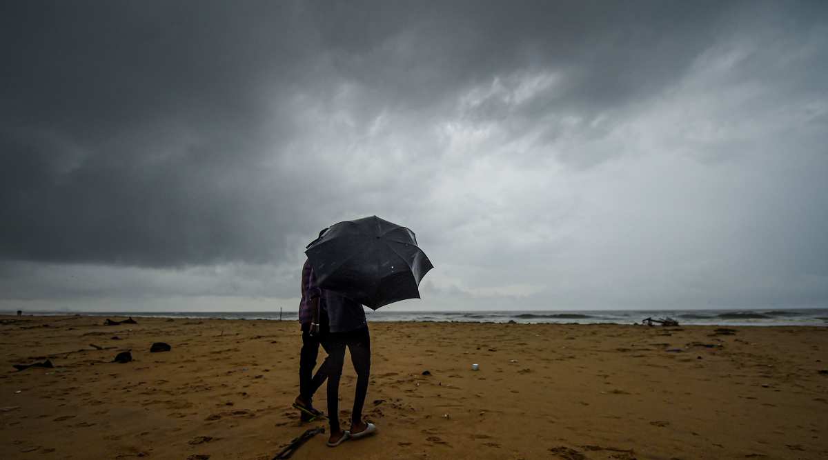 People walk on the shore during heavy rainfall, at Pattinapakkam in Chennai, Friday, Nov. 19, 2021. (PTI Photo/ R Senthil Kumar)
