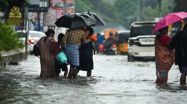 Commuters wade through a waterlogged area following heavy rain, in Chennai on  Nov. 10, 2021. (PTI)