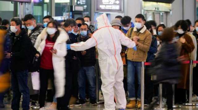 A security guard blocks an exit as he directs people to scan a QR code to track their health status at Shanghai Hongqiao Railway Station, following new cases of the coronavirus disease (COVID-19), in Shanghai, China, November 25, 2021.  (REUTERS/Aly Song)