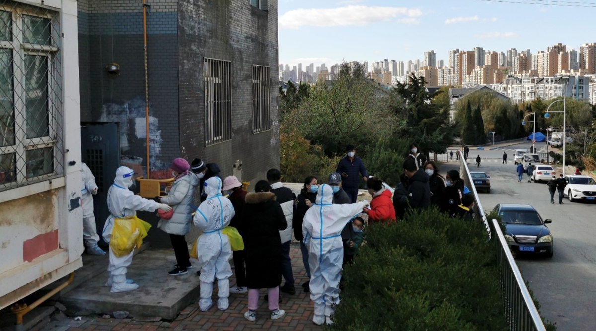 People line up for nucleic acid testing in the snow at a testing site in Jinpu New Area, following cases of the coronavirus disease (COVID-19) in Dalian, Liaoning province, China November 8, 2021. Picture taken November 8, 2021.  (Reuters)