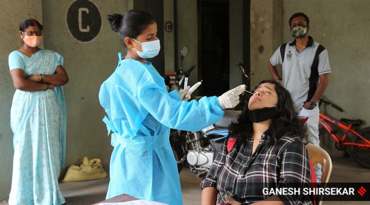 A health worker collects swab sample of a resident for Covid-19 test at Sion in Mumbai onTuesday. (Express photo by Ganesh Shirsekar)