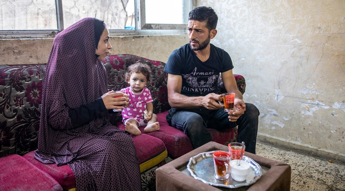 Wasfi al-Garosha with his wife, Samar, and daughter, Dina, on the morning he returned to jail in Gaza City, Sept. 30, 2021.  (Hosam Salem/The New York Times)
