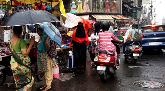 People caught unawares during unseasonal rain in Vadodara on Thursday. (Express Photo by Bhupendra Rana)
