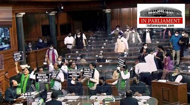 MPs hold placards and raise slogans as they protest in the Lok Sabha during the Winter Session of Parliament, in New Delhi, Tuesday, Nov. 30, 2021. (LSTV/PTI)

