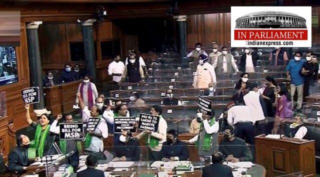 MPs hold placards and raise slogans as they protest in the Lok Sabha during the Winter Session of Parliament, in New Delhi, Tuesday, Nov. 30, 2021. (LSTV/PTI)