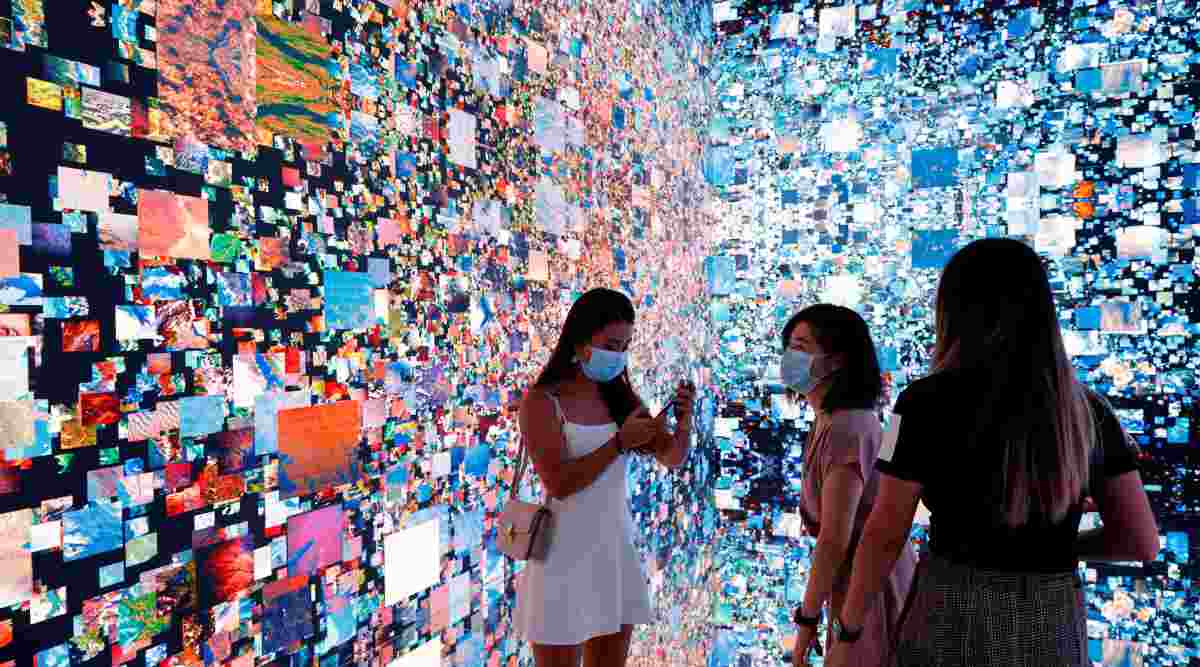 Visitors are pictured in front of an immersive art installation titled "Machine Hallucinations — Space: Metaverse" by media artist Refik Anadol, which will be converted into NFT and auctioned online at Sotheby's, at the Digital Art Fair, in Hong Kong, China September 30, 2021. (Reuters Photo: Tyrone Siu)