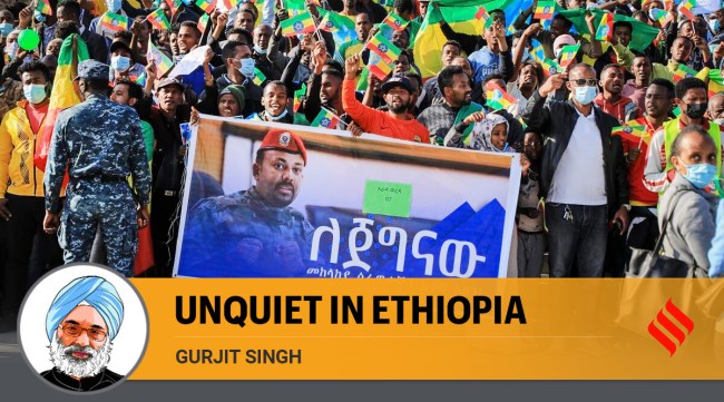 People gather behind a placard showing Prime Minister Abiy Ahmed at a rally organized by local authorities to show support for the Ethiopian National Defense Force (ENDF), at Meskel square in downtown Addis Ababa, Ethiopia (AP)