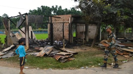 A paramilitary soldier patrols past a shop that was set on fire in Rowa village, about 220 kilometers from Agartala. (AP)