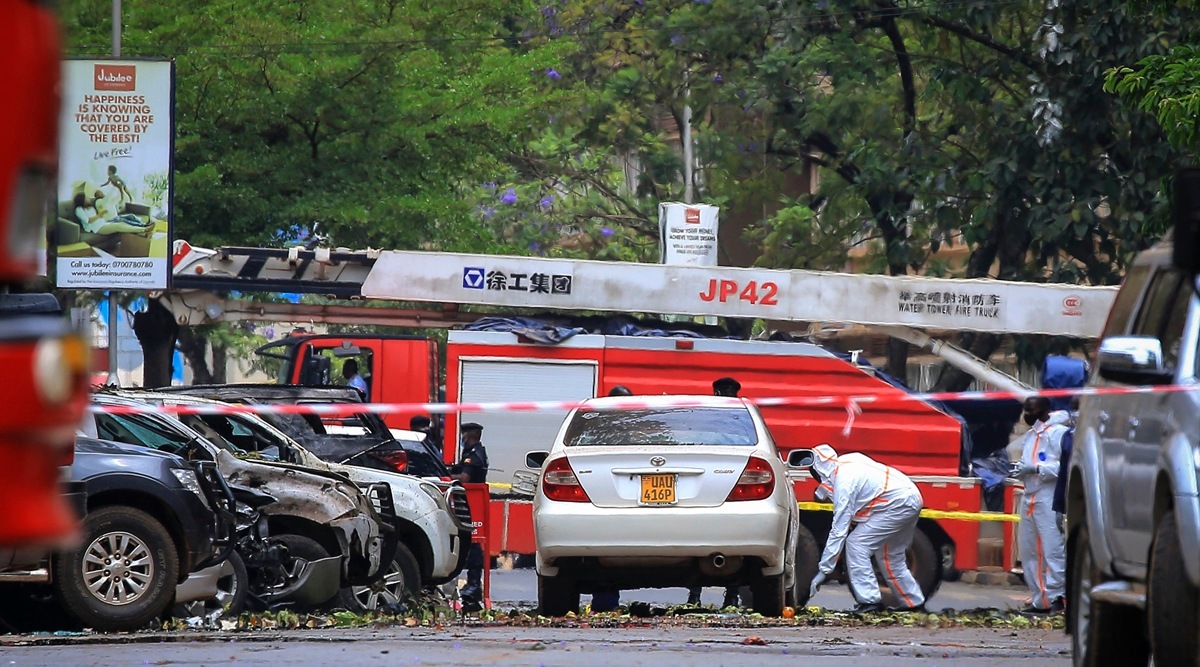 Security forces and forensics officers examine the scene of a blast on a street near the parliamentary building in Kampala, Uganda, Tuesday, Nov. 16, 2021. (AP)