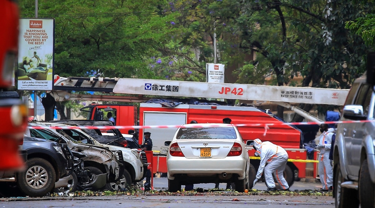 Security forces and forensics officers examine the scene of a blast on a street near the parliamentary building in Kampala, Uganda, Tuesday, Nov. 16, 2021. (AP)