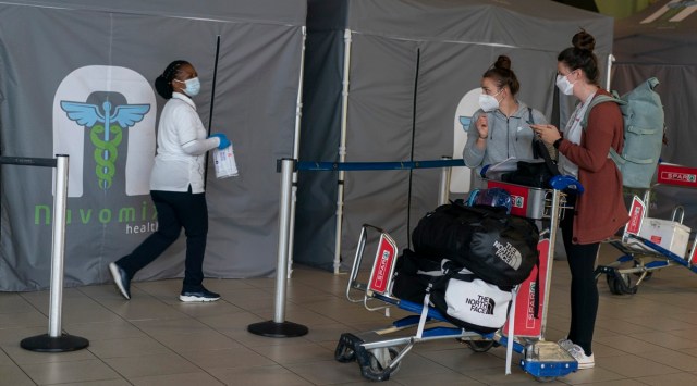 International travelers wait to take PCR tests upon arriving at the O.R. Tambo International airport in Johannesburg, Nov. 27, 2021.  (Joao Silva/The New York Times)