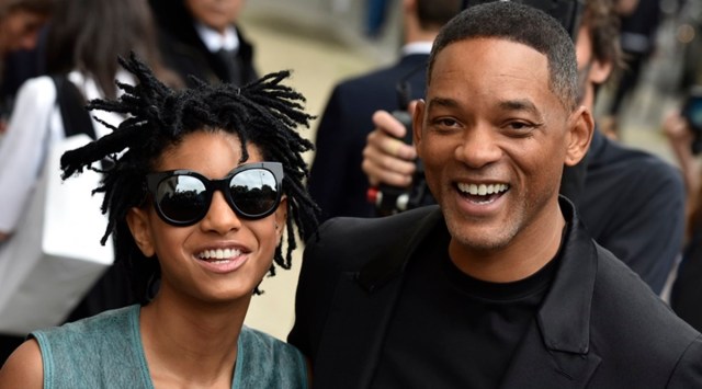 Willow Smith and her father actor Will Smith smile as they arrive at Chanel fashion show. (Source: AP Photo/Zacharie Scheurer)
