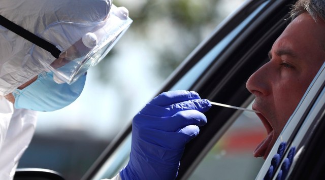 A medical staff takes a sample for a voluntary coronavirus disease test (COVID-19) at the new corona test station at the 'Hochfelln' service station. (AP)