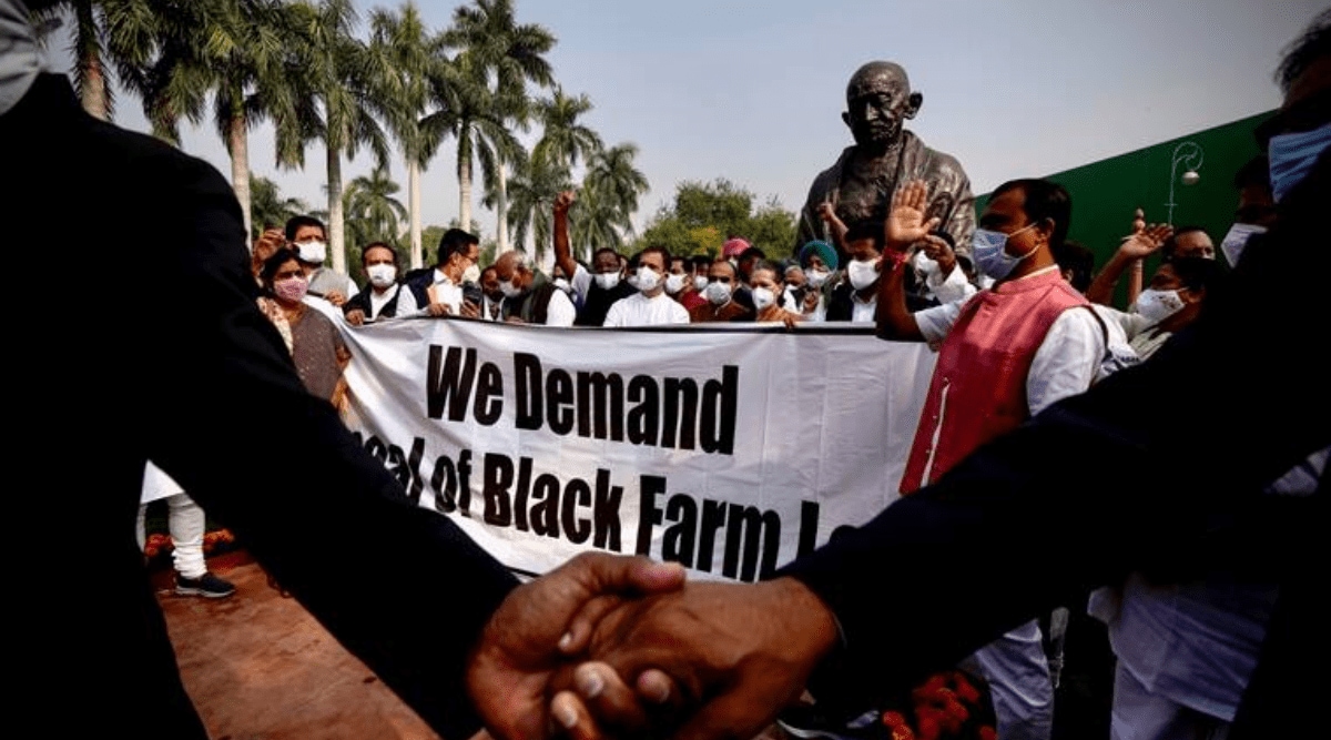 Opposition lawmakers hold a protest near a Gandhi statue demanding repeal of three controversial farm laws on the opening day of the winter session of Parliament in New Delhi, India, Monday, Nov.29, 2021. (AP)