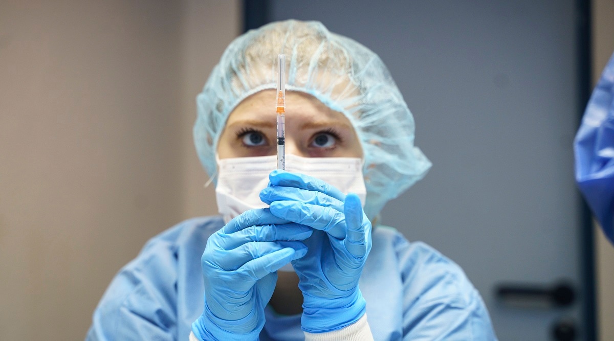 A staff member draws up a syringe with the Pfizer vaccine at the launch of COVID-19 booster vaccinations campaign at the police vaccination centre in Mainz, Germany. (AP)