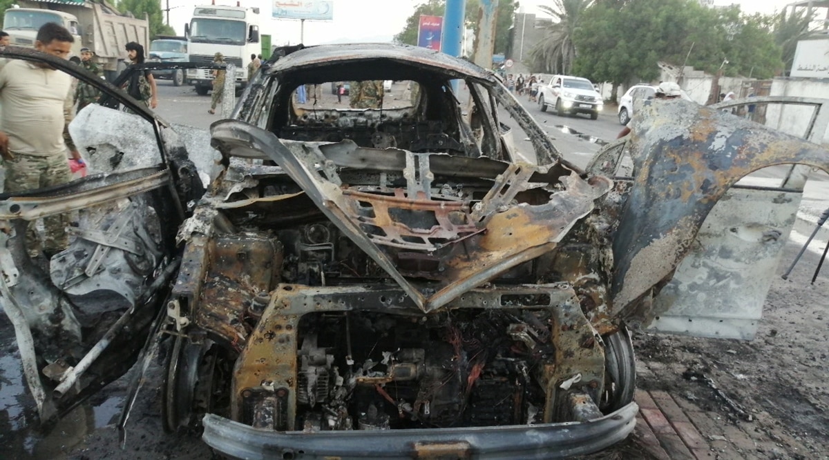 A security man inspects the wreckage of a car at the site of an explosion that killed a journalist in Aden, Yemen on November 9, 2021. (Reuters)
