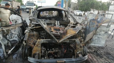 A security man inspects the wreckage of a car at the site of an explosion that killed a journalist in Aden, Yemen on November 9, 2021. (Reuters)