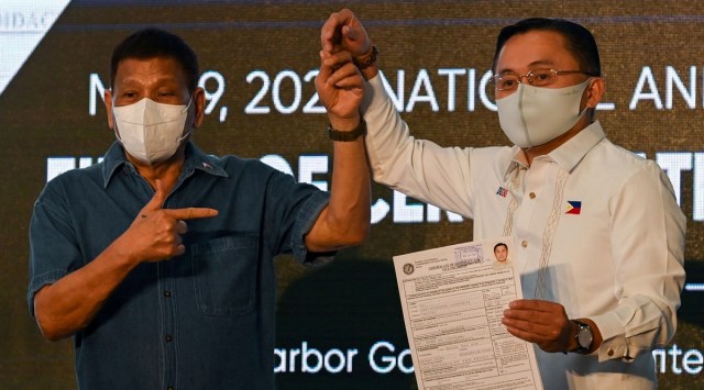 Philippine Senator Christopher "Bong" Go, accompanied by Philippine President Rodrigo Duterte, files his certificate of candidacy to join the vice presidential race, at Sofitel Harbor Garden Tent, in Pasay City, Metro Manila, Philippines, October 2, 2021. (Reuters)