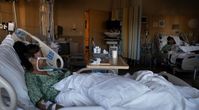 Natalie Balli, 71, and her twin sister, Linda Calderon, background right, watch TV as they rest in their beds in a COVID-19 unit at Providence Holy Cross Medical Center in Los Angeles. (AP)