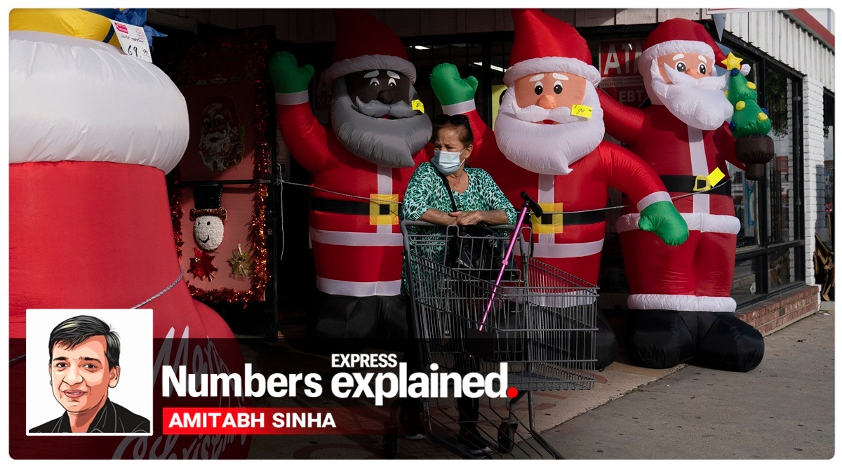 A shopper wearing a face mask pushes an empty cart past inflatable Santa Clauses as she leaves a discount store in Inglewood, California (AP Photo/Jae C. Hong)