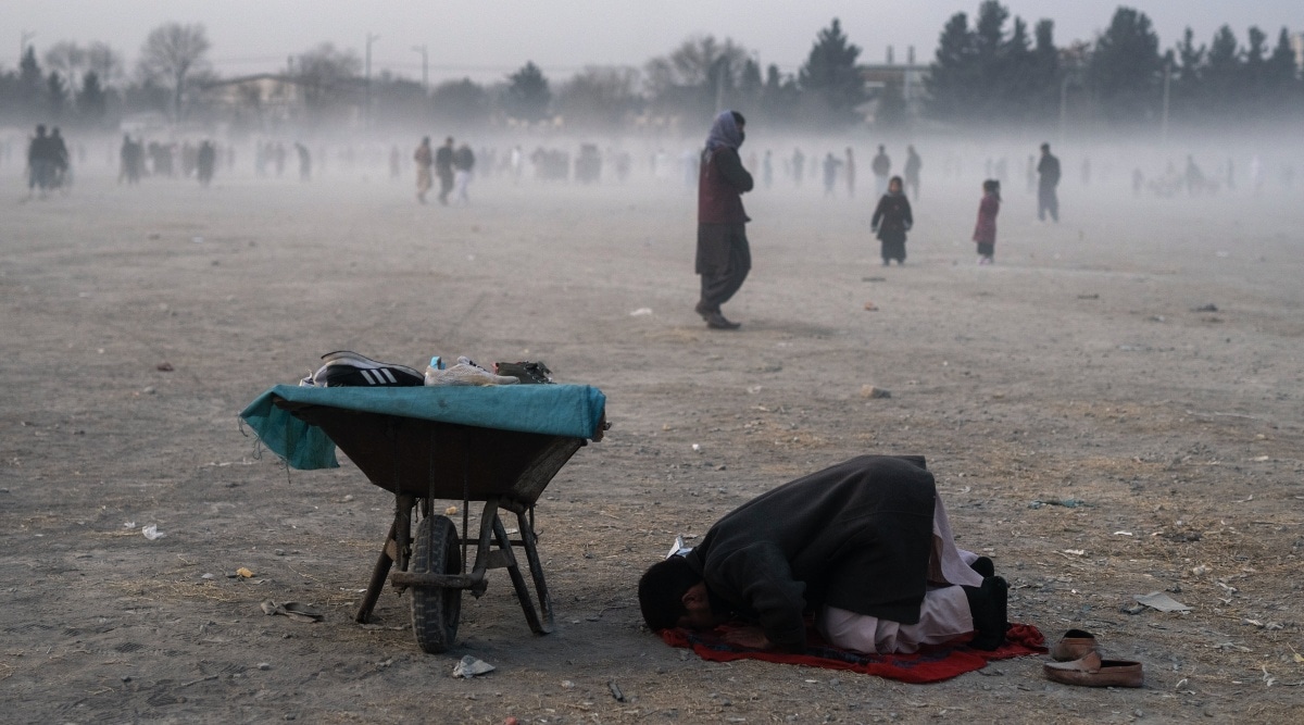 A second hand shoes street vendor prays in Chaman-e-Hozori park, Kabul, Afghanistan, Friday, Dec. 3 , 2021. (AP Photo/ Petros Giannakouris)