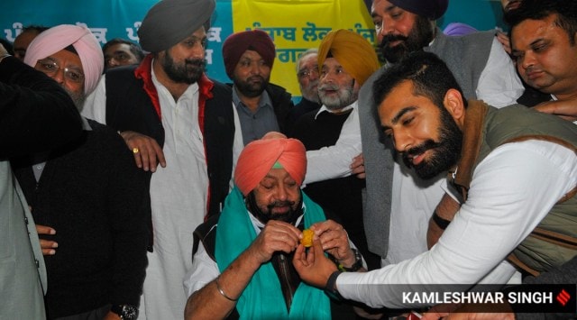 A supporter shares sweets with Capt Amarinder Singh as his son Raninder looks on, during the inauguration of Punjab Lok Congress' office, in Chandigarh, Monday. Kamleshwar Singh