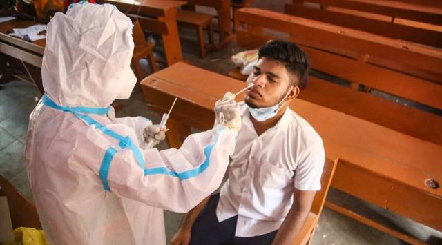 A Nagercoil Municipal Corporation worker takes swab sample of a student for Covid-19 test, at a school in Kanyakumari district. (PTI)