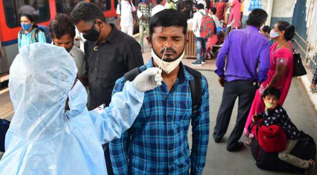 A BMC health worker collects swab sample of an outstation passenger for COVID-19 test, at Dadar railway station, in Mumbai, Saturday, December 18, 2021. (PTI Photo)