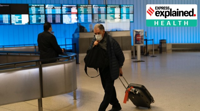 A traveler adjusts his face mask as he walks through the arrivals area at the Los Angeles International Airport in Los Angeles, Nov. 30, 2021. (AP Photo/Jae C. Hong, File)
