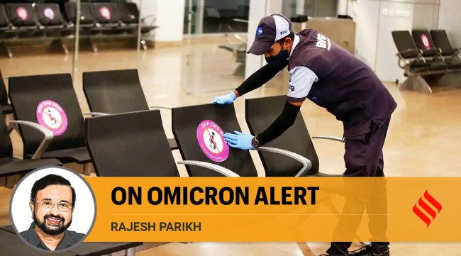 A worker sticks social distancing markers at Sardar Vallabhbhai Patel International airport amid concern over 'Omicron' variant of coronavirus, in Ahmedabad (PTI Photo)
