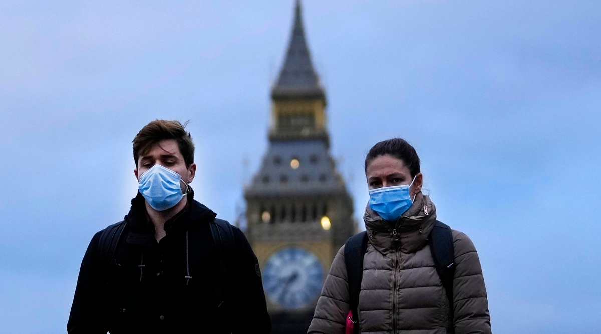 People wearing a face covering walk across Westminster Bridge in London, Wednesday, Dec. 15, 2021. (AP)