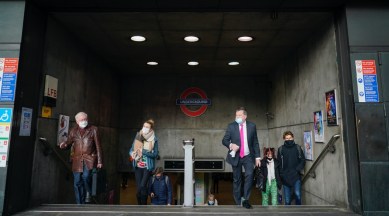 People wear masks as they exit Westminster Underground station, in London, Thursday, Dec. 9, 2021. (AP Photo/Alberto Pezzali)