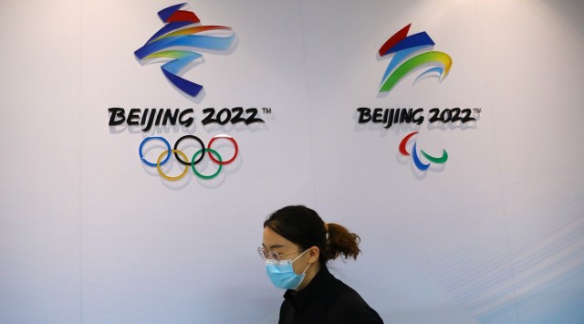 A staff member walks past logos of the Beijing 2022 Winter Olympics at an exhibition room. (Reuters)
