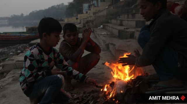 Children sit by a fire at Yamuna Bank in New Delhi on Friday. (Express Photo: Amit Mehra)