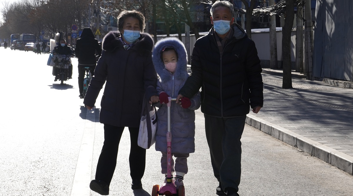 Residents wearing masks walk on a street in Beijing, China. (AP)