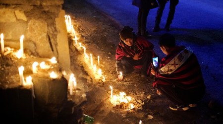 A Naga man takes a photograph of another lighting a candle in memory of fourteen civilians killed by Indian army soldiers earlier this month. (AP)