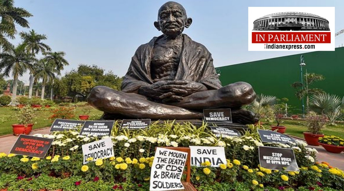 Placards placed near Mahatma Gandhi's statue by the suspended Rajya Sabha MPs, who discontinued their protest for today after observing a minute of silence for IAF Mi-17V5 helicopter crash in Tamil Nadu, in which CDS Gen Bipin Rawat, his wife Madhulika Rawat, his staff and other officials were killed, at Parliament in New Delhi, Thursday, Dec. 9, 2021.  (PTI)