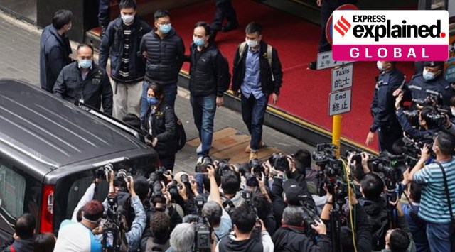 Editor of Stand News Patrick Lam, fourth from left, is escorted by police officers into a van after they searched for evidence at his office in Hong Kong, Wednesday, Dec. 29, 2021. (AP)